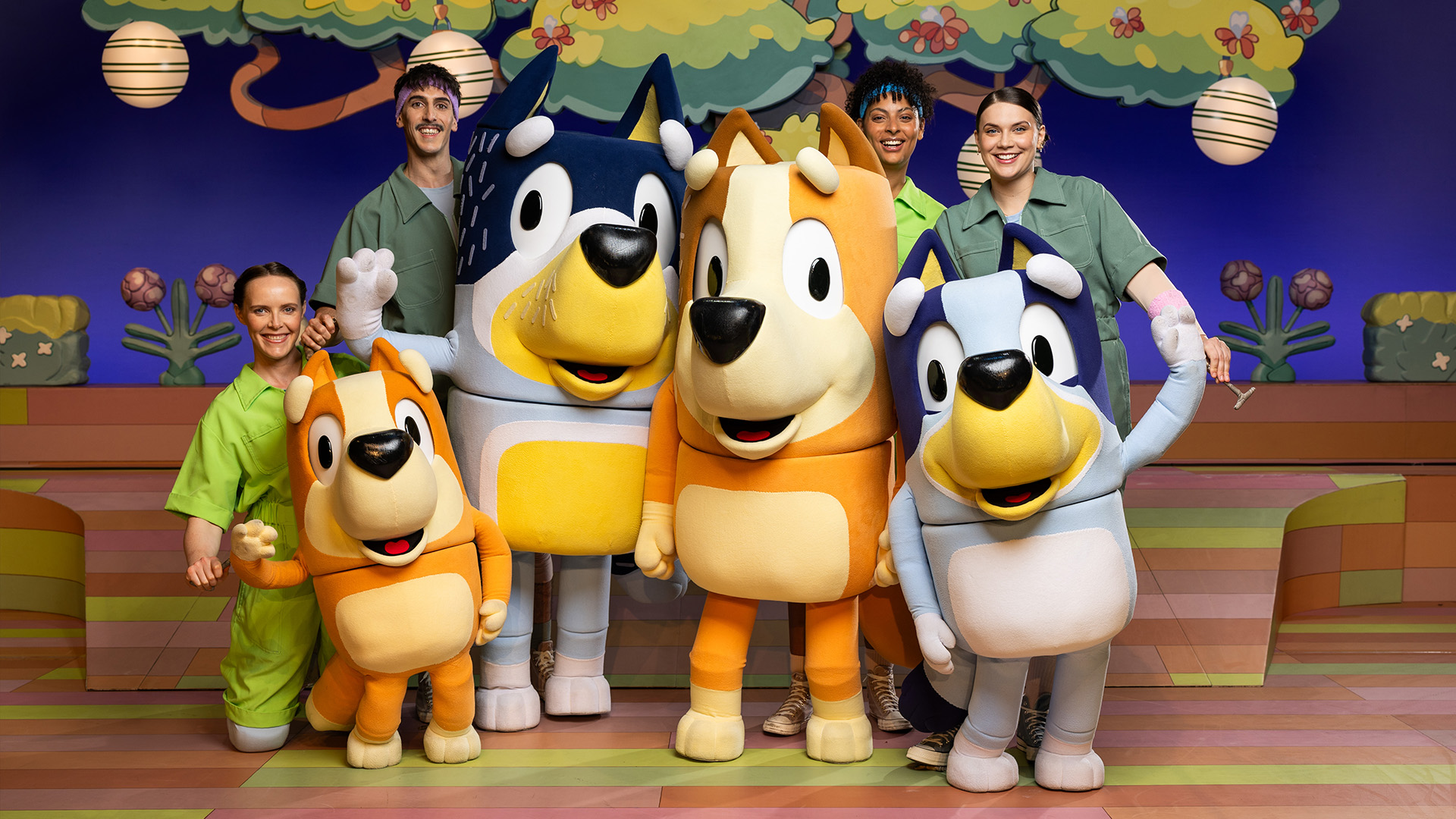 "Bluey's Big Play" cast members pose with "Bluey" puppets.