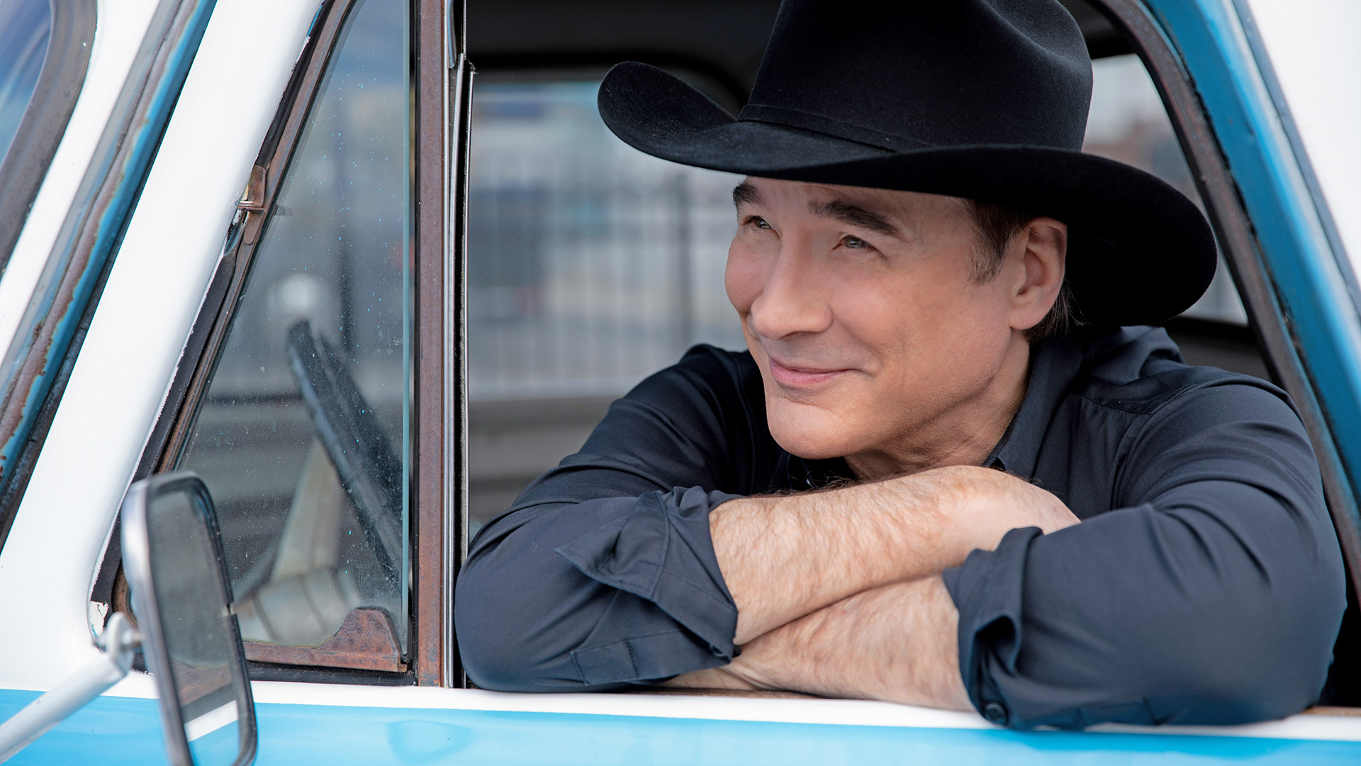 Image: Country singer Clint Black poses for a photograph inside a vintage vehicle.