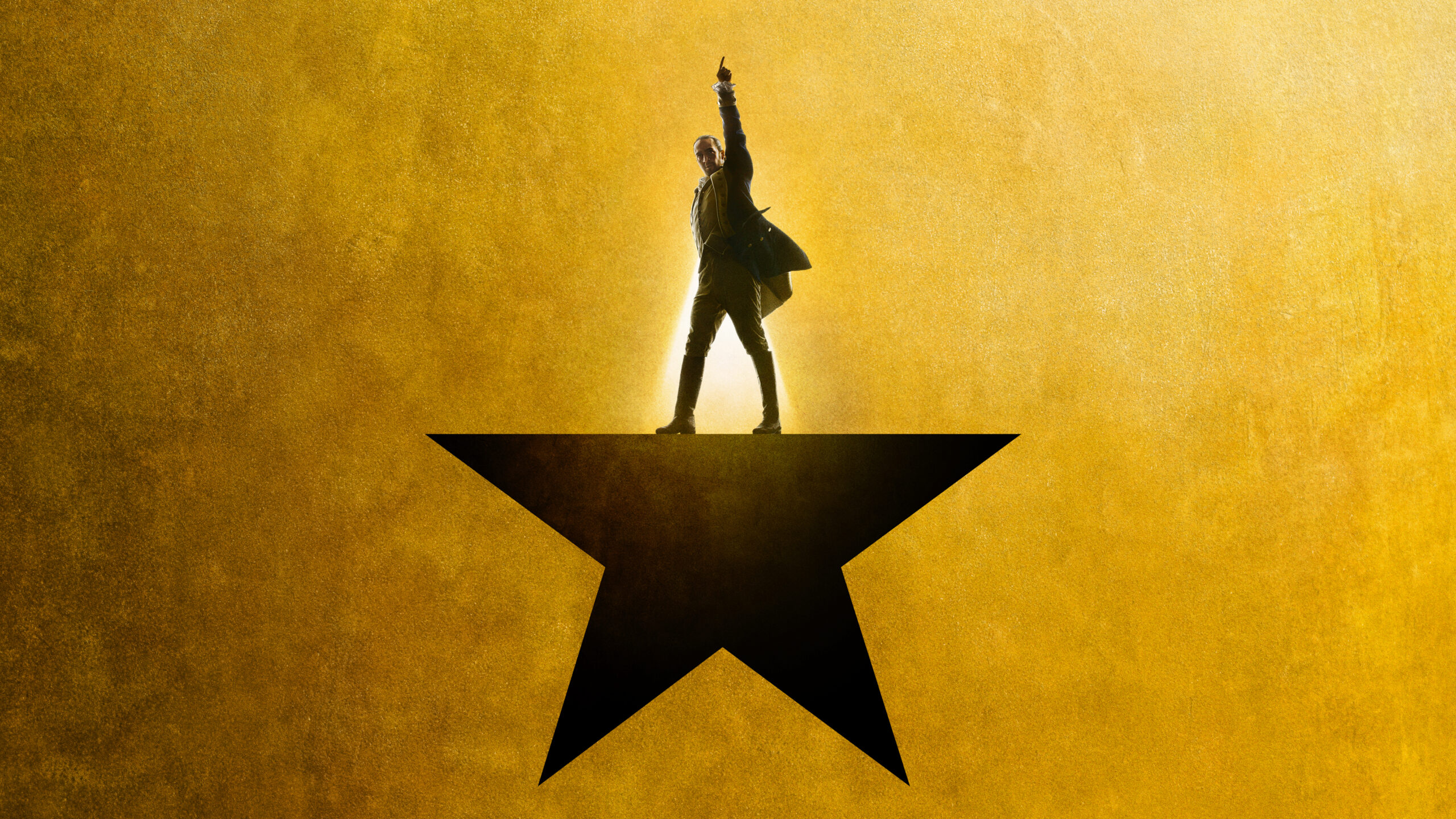 Promotional graphic for the film "Hamilton."  A silhouetted man stands atop a star on a gold background.