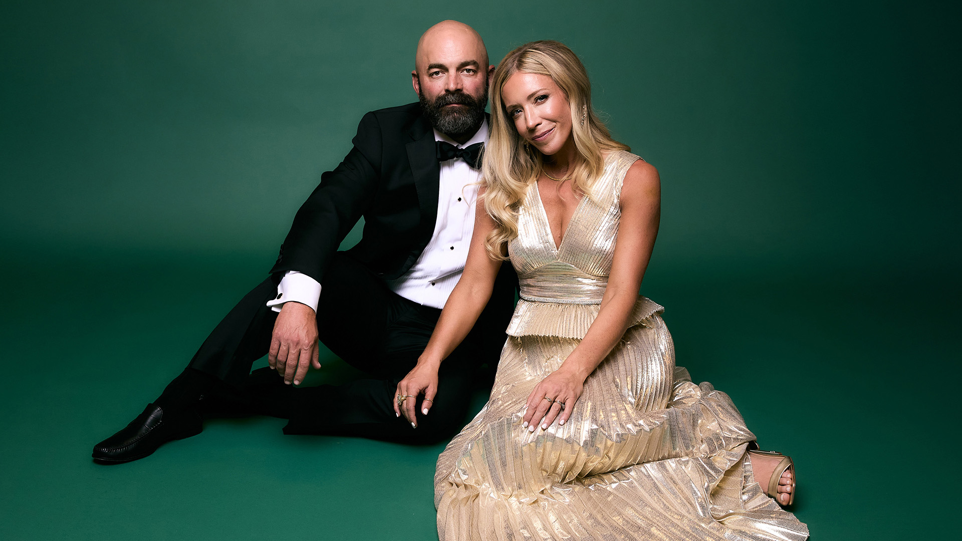 Drew Holcomb and Ellie Holcomb sitting together in formal attire.