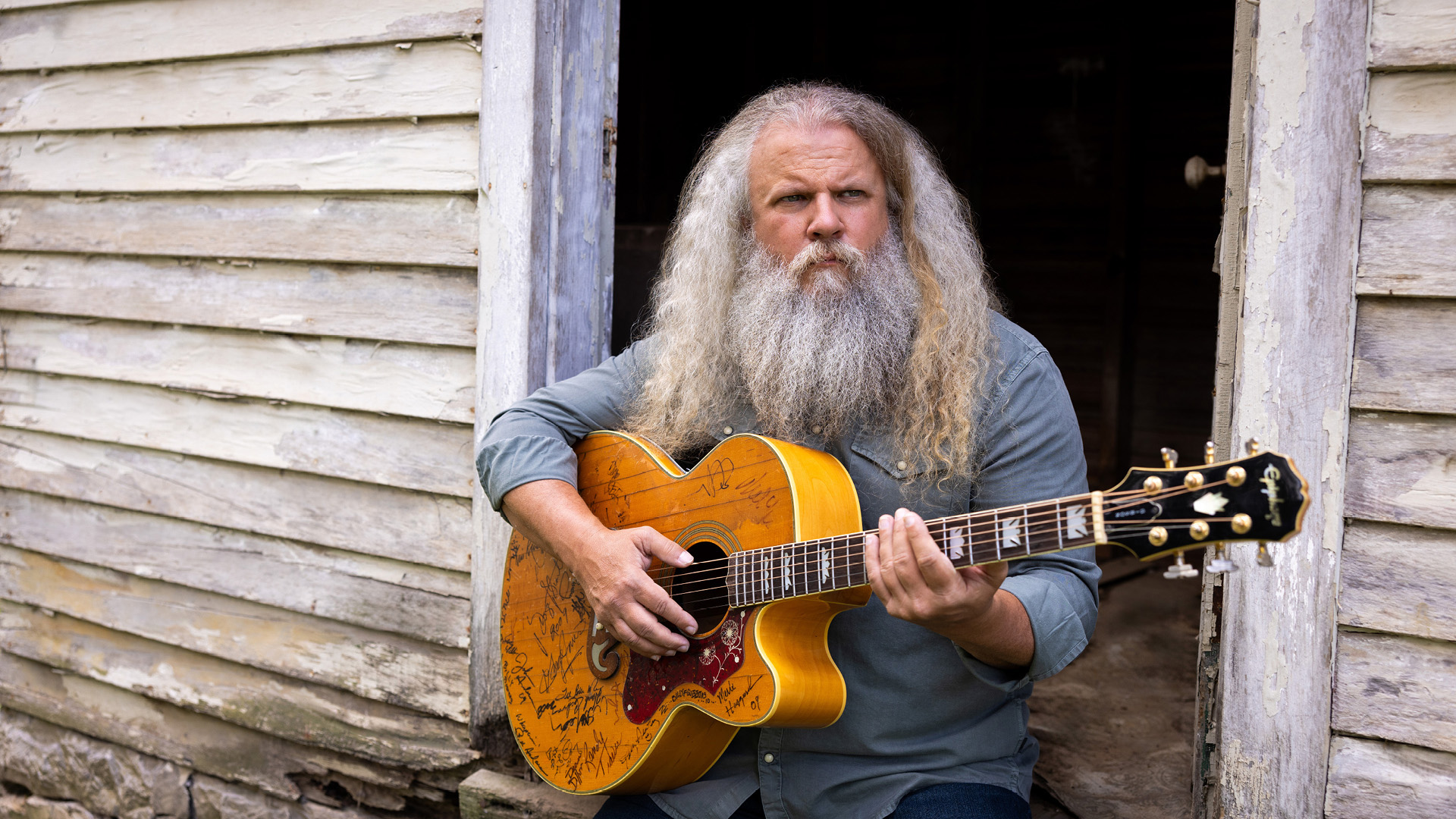 Jamey Johnson sitting with his guitar.