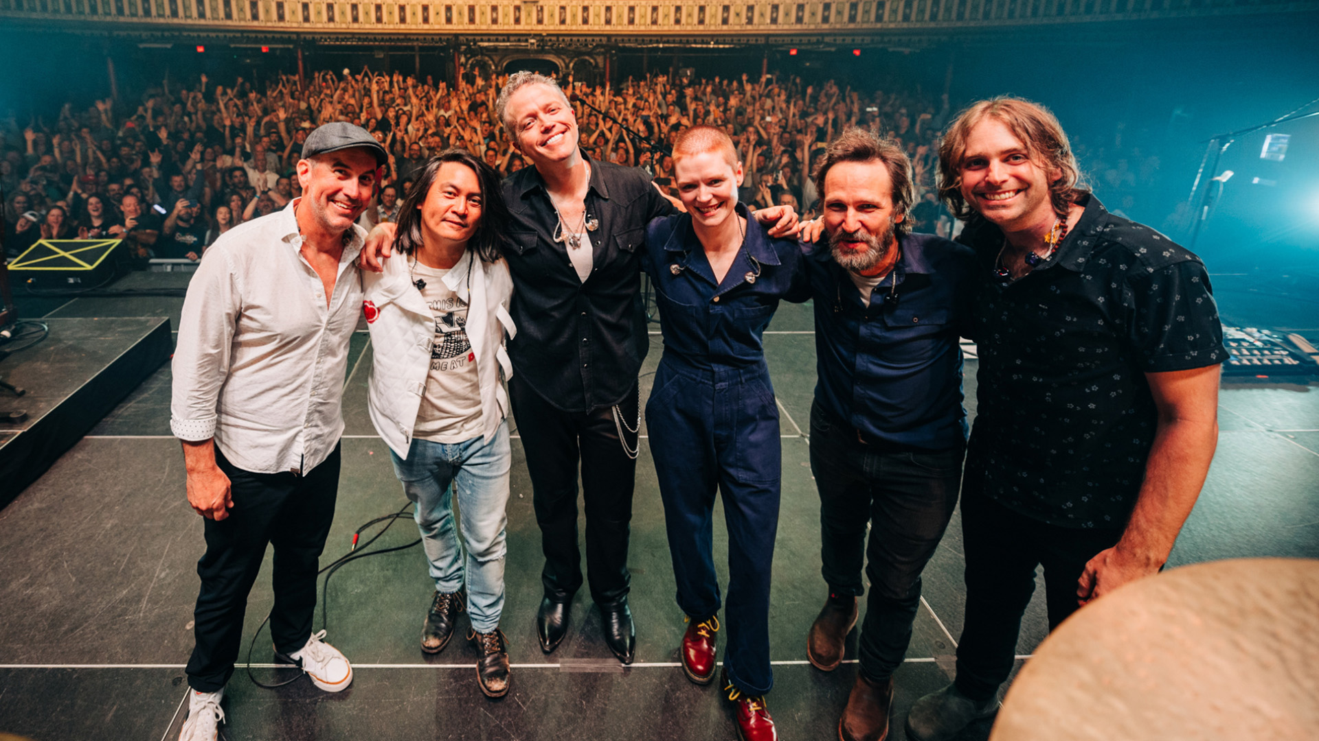 Jason Isbell and members of 400 Unit on stage in front of cheering crowd.
