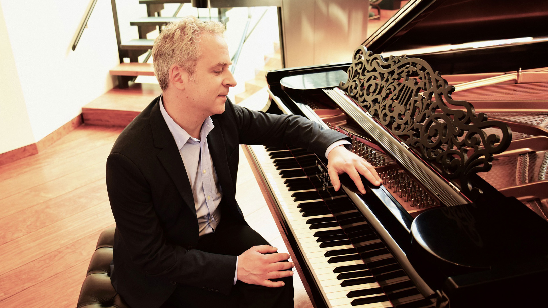 Jeremy Denk sitting at a piano.