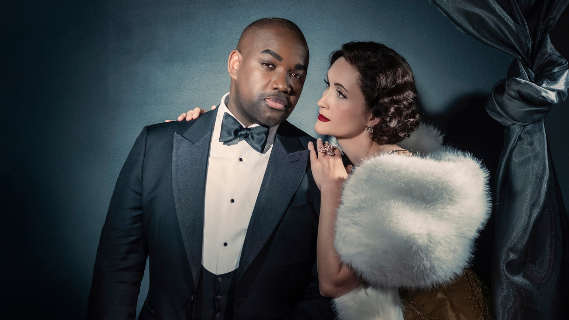 Erin Morley holding Lawrence Brownlee dressed in tuxedo.
