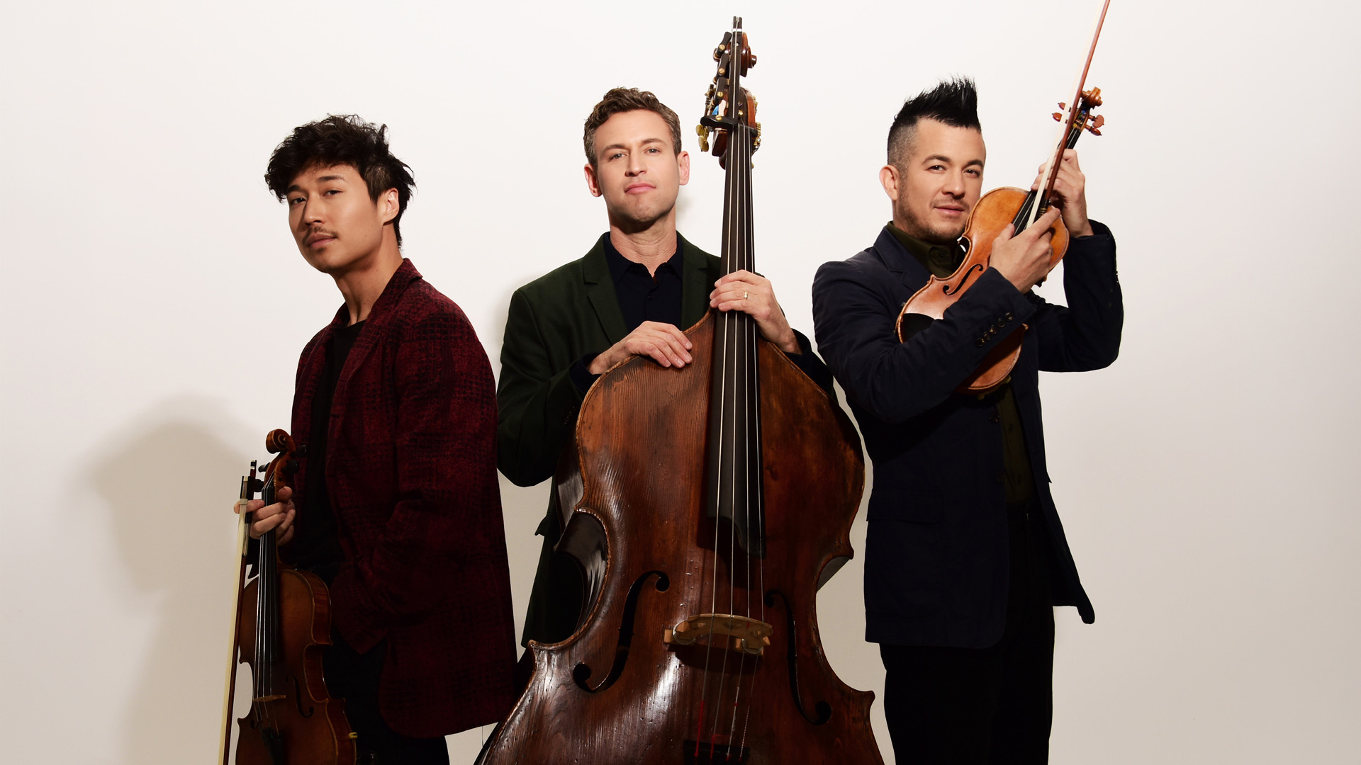 Time for Three members standing together with their instruments.