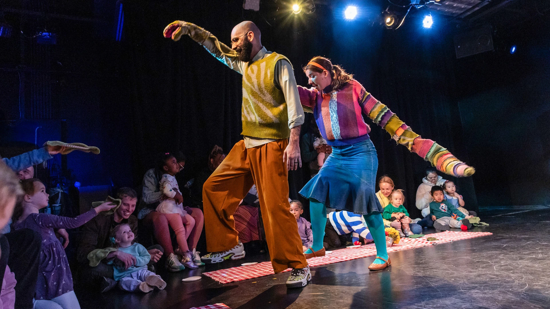 Two actors in Dinosaur! performing a scene for an audience of small children and parents.